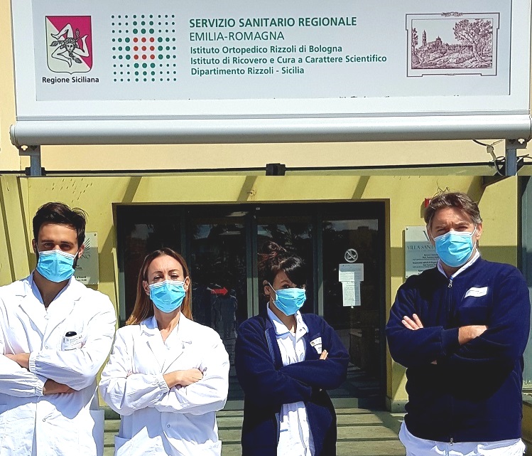 Operatori sanitari davanti all'ingresso del Dipartimento Rizzoli-Sicilia a Bagheria (Palermo)