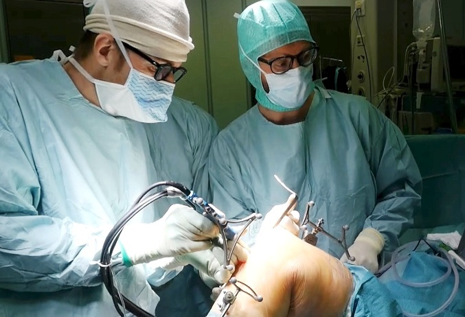 Il prof. Cesare Faldini, a sinistra, durante l'intervento chirurgico.